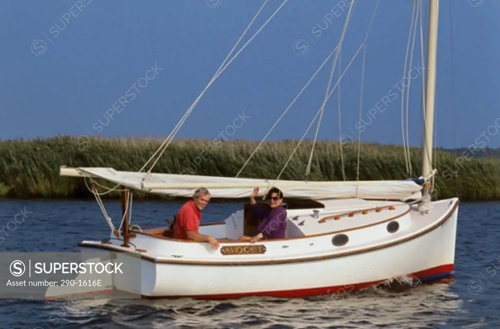 Mature couple sitting on a sailboat