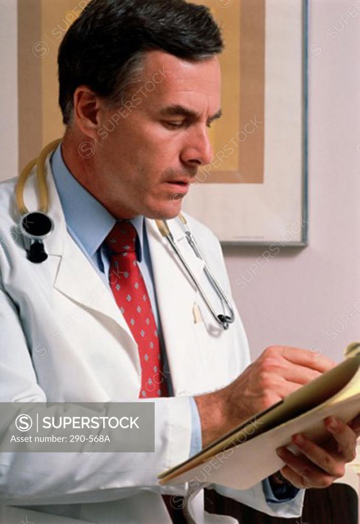 Stock Photo: 290-568A Male doctor reading a report
