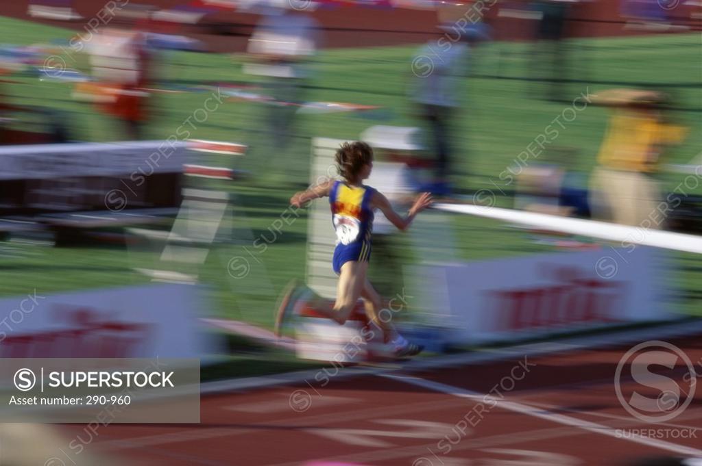 Stock Photo: 290-960 Rear view of a female athlete crossing the finish line