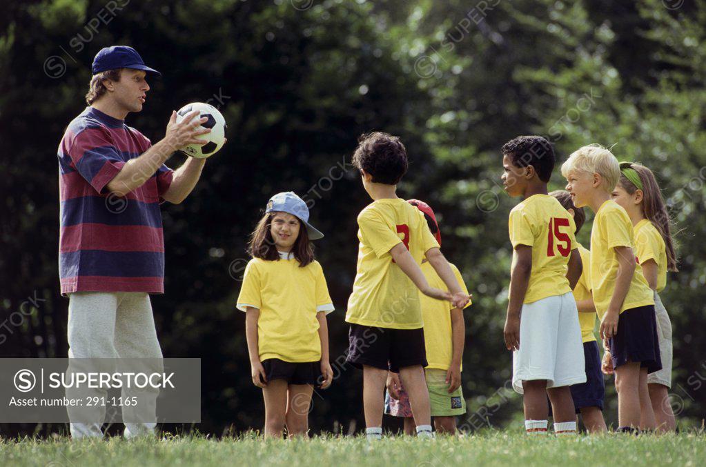 Stock Photo: 291-1165 Coach giving instructions to soccer players on a soccer field