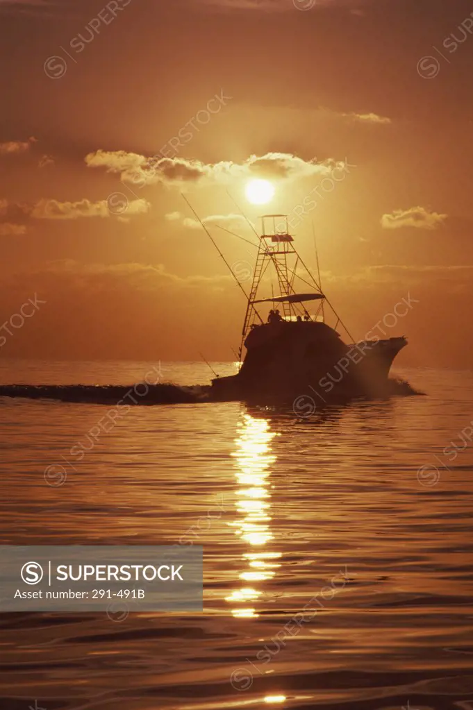 Silhouette of a fishing boat in the sea at sunset