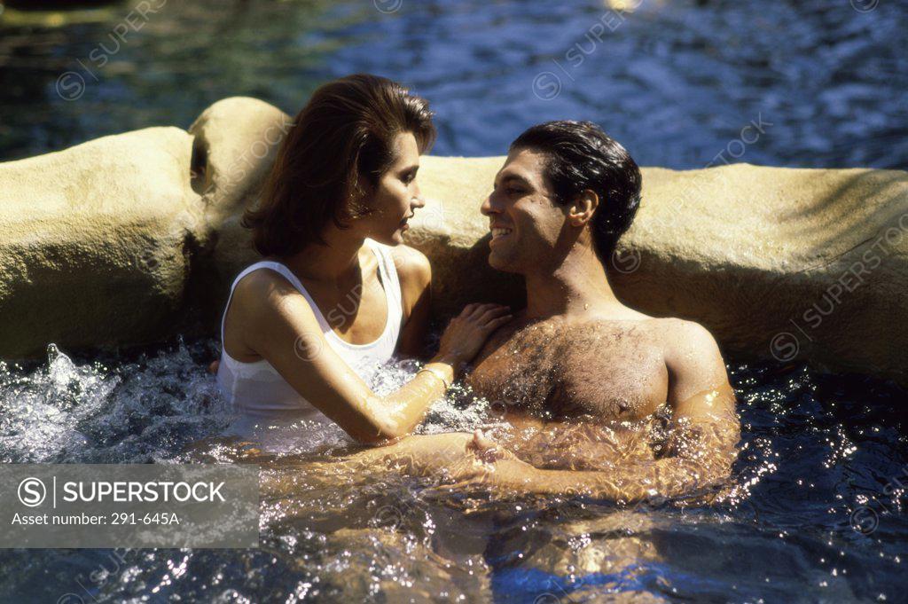Stock Photo: 291-645A Young couple in a hot tub and smiling