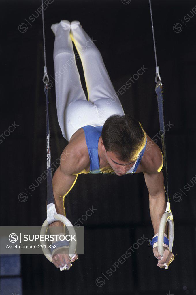 Stock Photo: 291-853 Young man doing a handstand on gymnastic rings