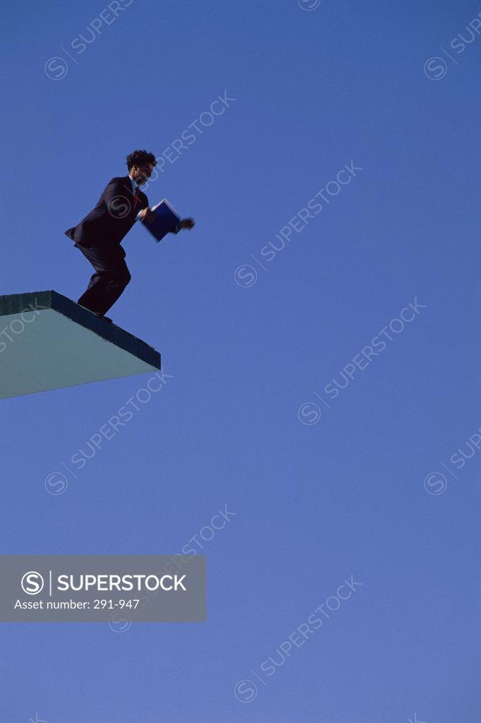 Stock Photo: 291-947 Low angle view of a businessman jumping from a diving board