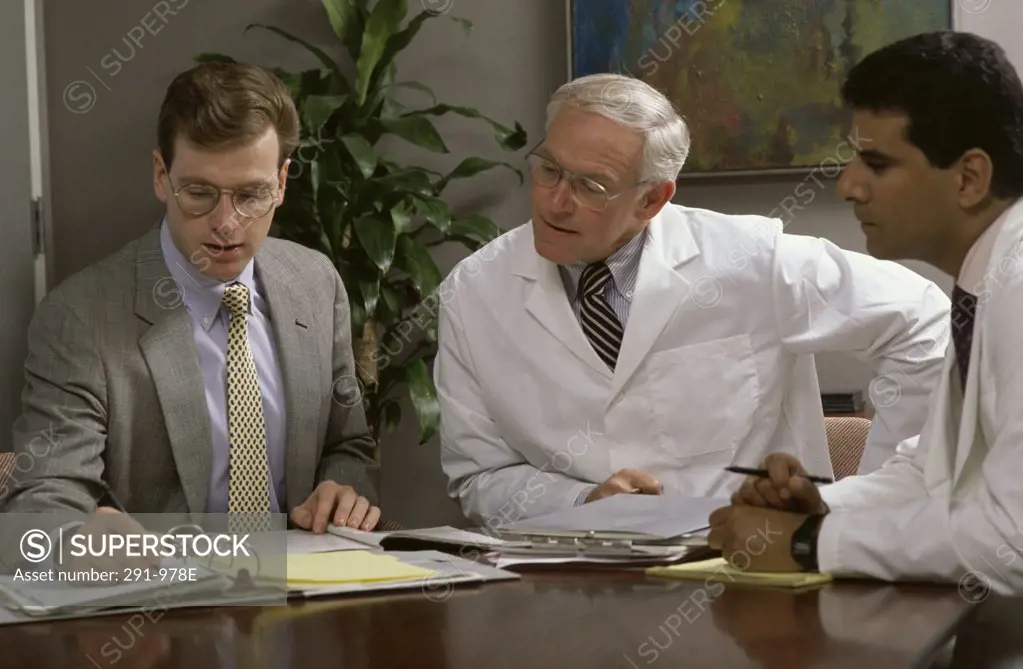 Three male doctors talking in a conference room