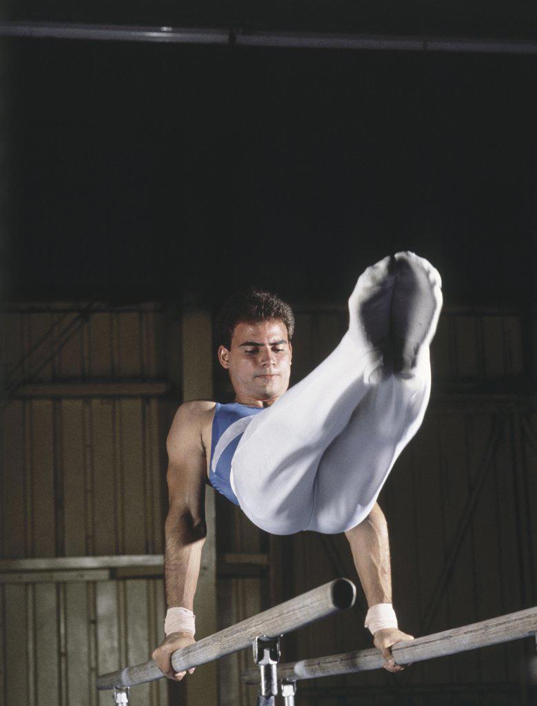 Young man performing on parallel bars