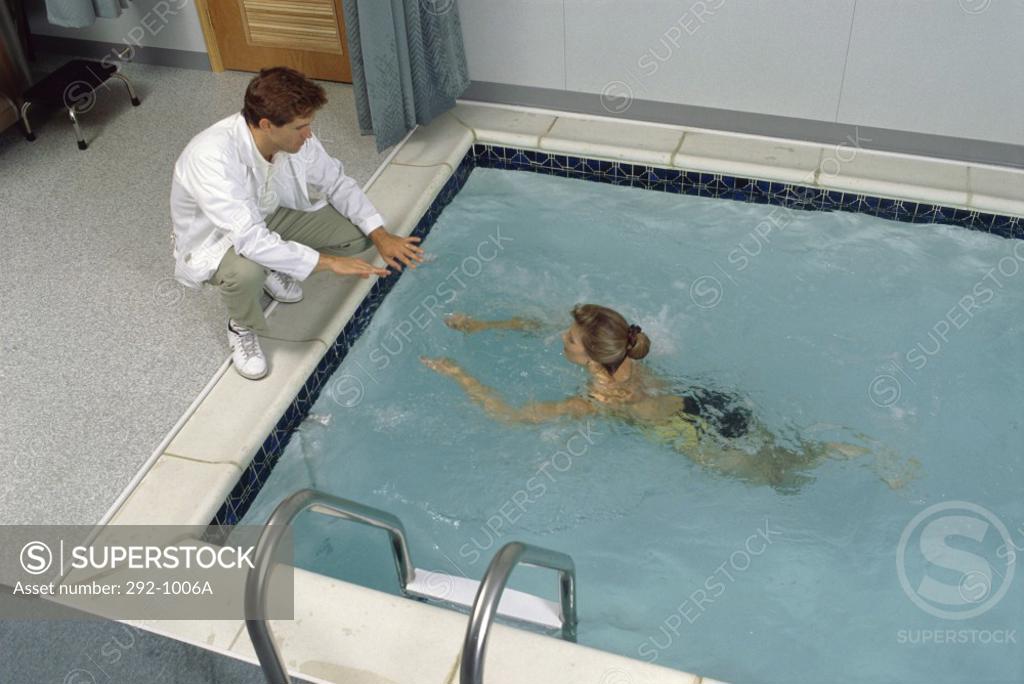 Stock Photo: 292-1006A High angle view of a physical therapist guiding a patient in the swimming pool