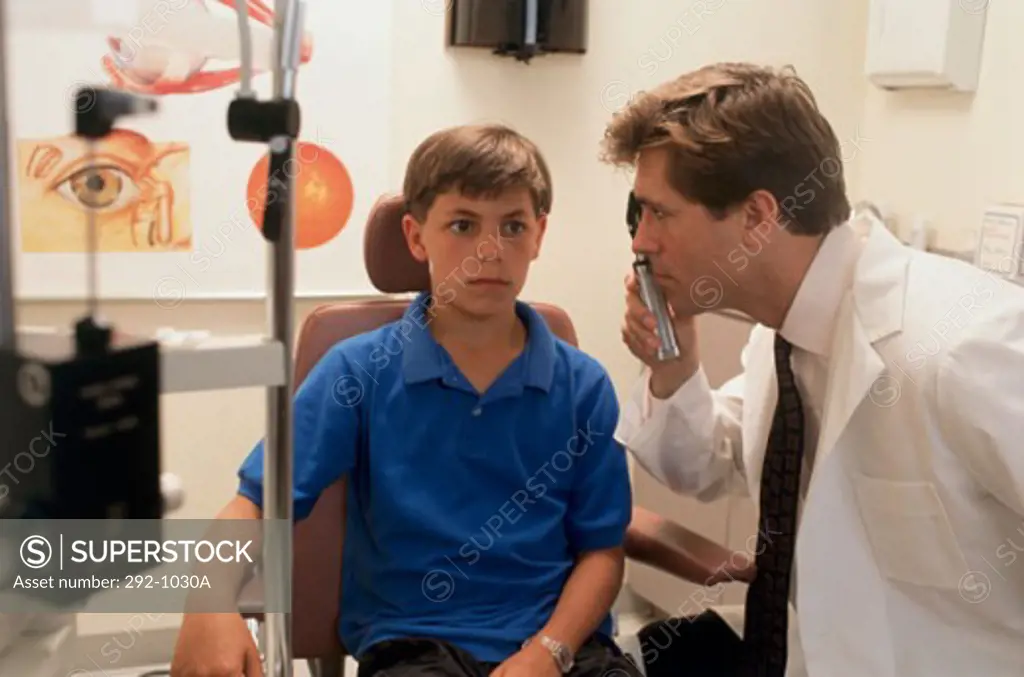 Side profile of an ophthalmologist examining a boy