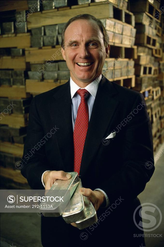 Stock Photo: 292-1153A Businessman holding silver bars and smiling