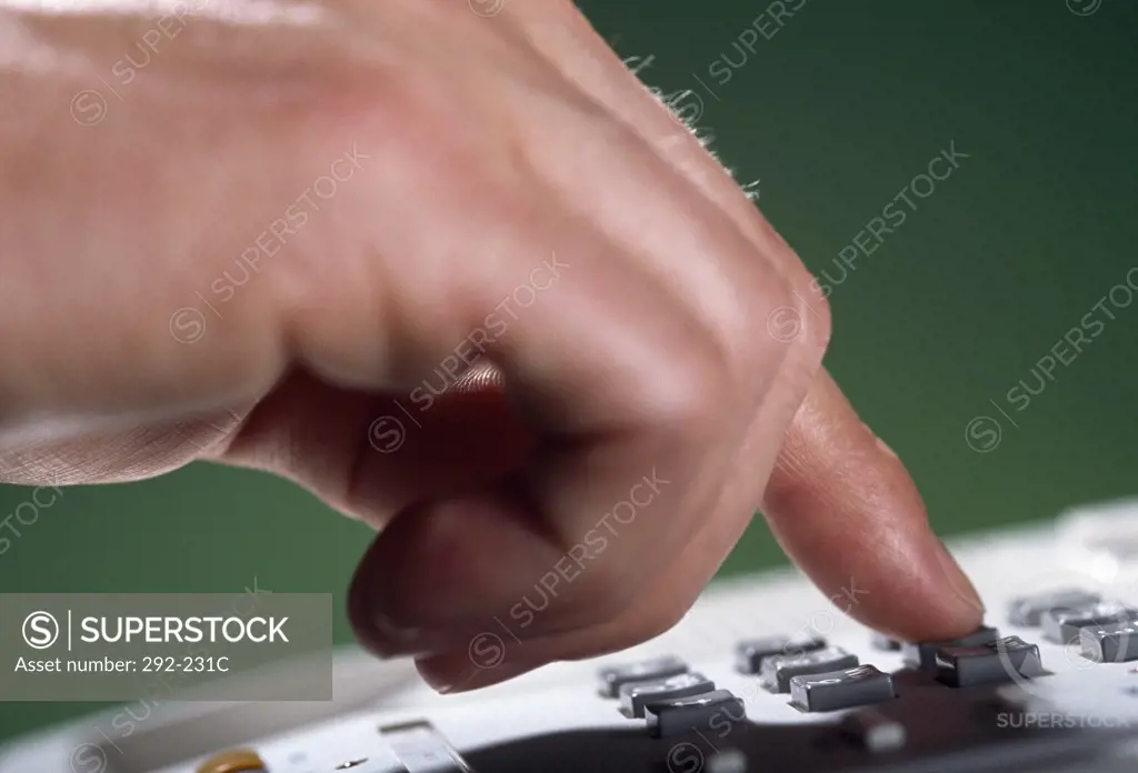 Close-up of a person's hand operating a telephone
