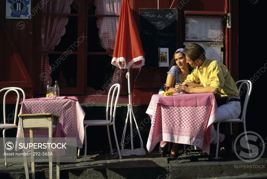 Young couple sitting in a sidewalk cafe