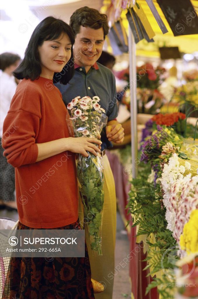 Stock Photo: 292-665A Young couple buying flowers from a flower shop and smiling