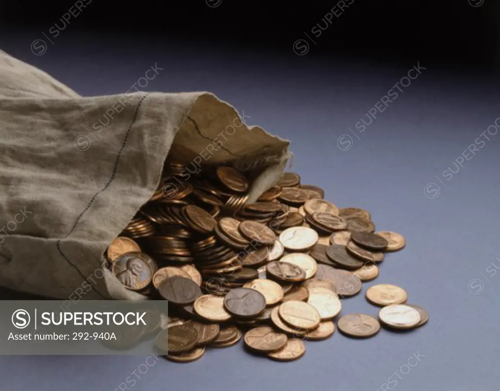Close-up of coins spilling from a bag