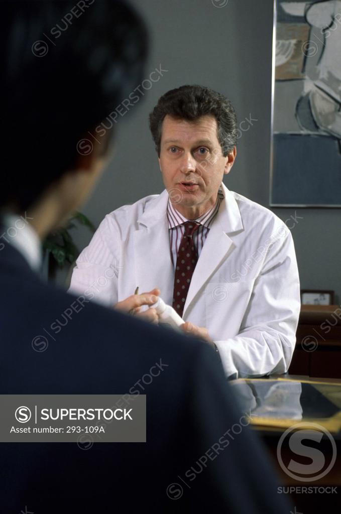 Stock Photo: 293-109A Male doctor explaining medication to a patient in a doctor's office