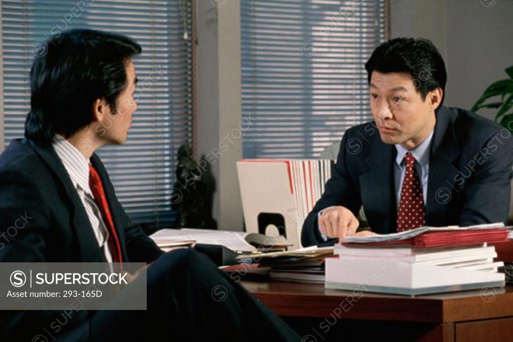 Stock Photo: 293-165D Two businessmen sitting in an office discussing