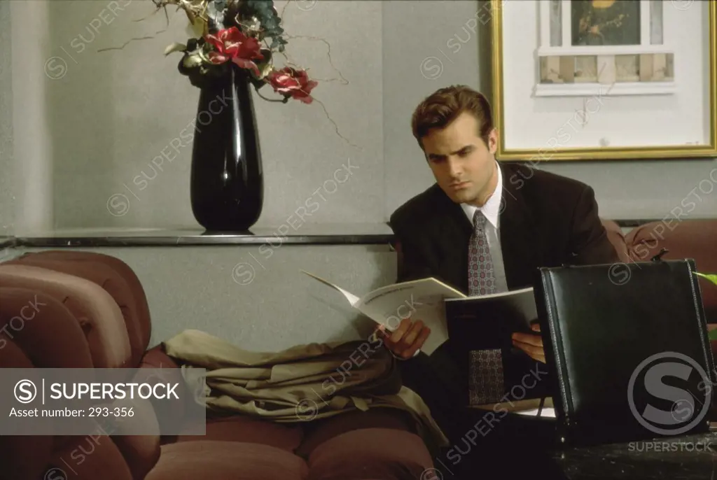 Businessman sitting in an office and reading a file