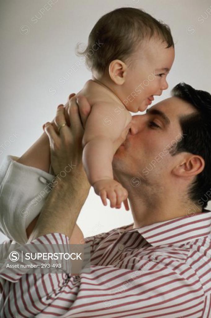 Stock Photo: 293-493 Young man kissing his baby's chest