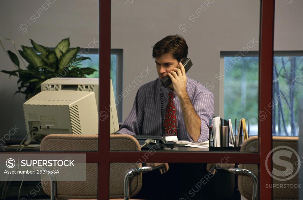 Stock Photo: 293-553A Businessman talking on the telephone in an office