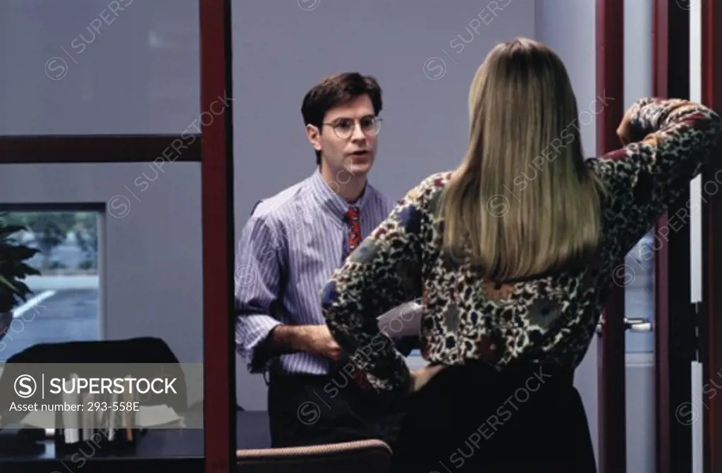 Businessman talking with a businesswoman in an office
