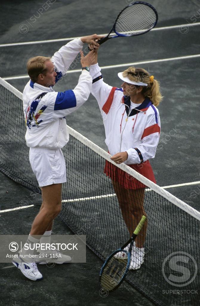 Stock Photo: 294-115A Mid adult man teaching tennis to a young woman