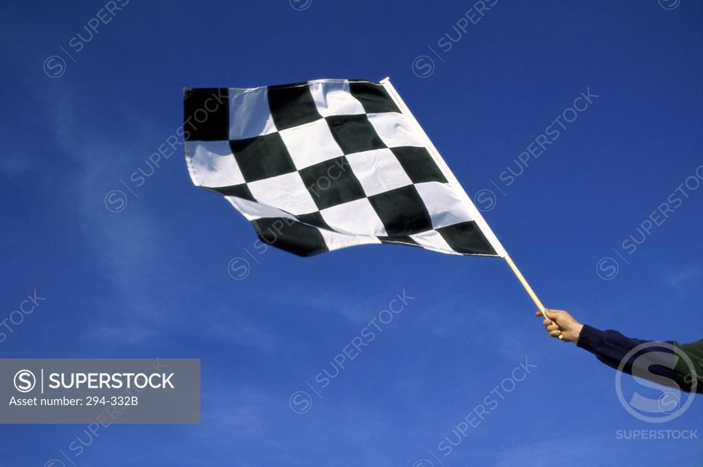 Stock Photo: 294-332B Low angle view of a man's hand waving a checkered flag