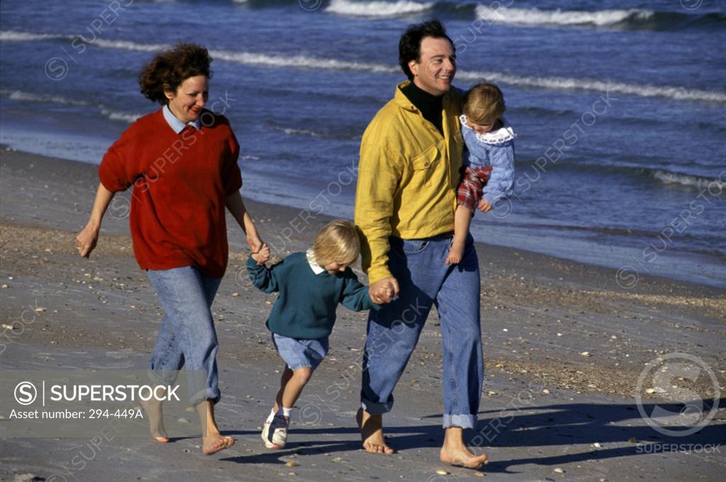 Stock Photo: 294-449A Mid adult couple with their children walking on the beach