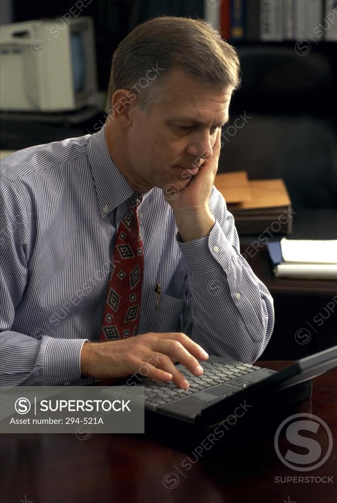 Stock Photo: 294-521A Businessman using a laptop in an office