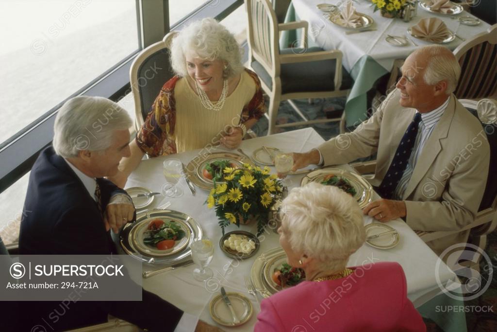 Stock Photo: 294-721A High angle view of two senior couples talking at a dining table