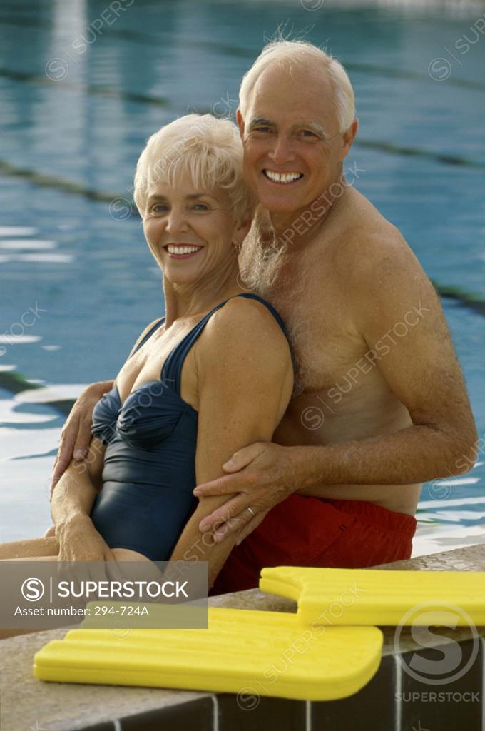 Stock Photo: 294-724A Senior couple sitting at poolside and smiling
