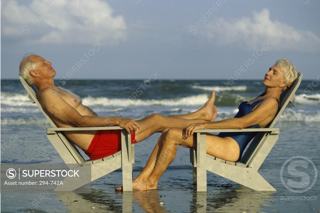Stock Photo: 294-742A Senior couple sitting in Adirondack chairs