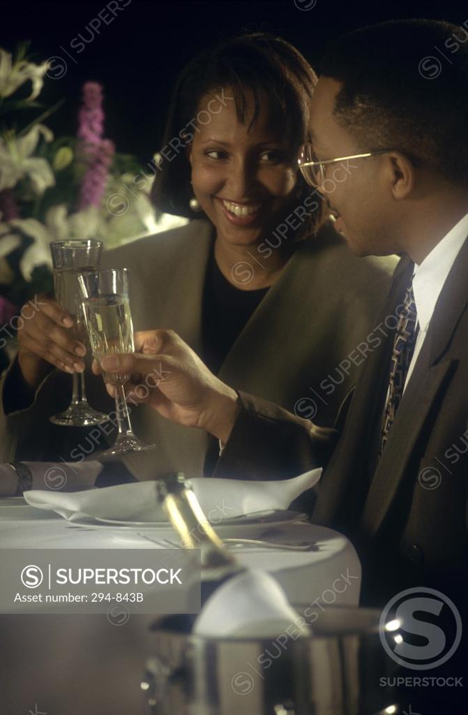 Stock Photo: 294-843B Young couple toasting with champagne and smiling