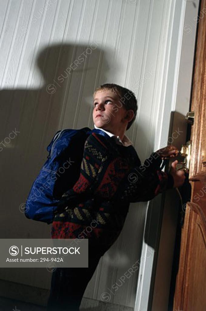 Stock Photo: 294-942A Boy looking frightened from the shadow of a person