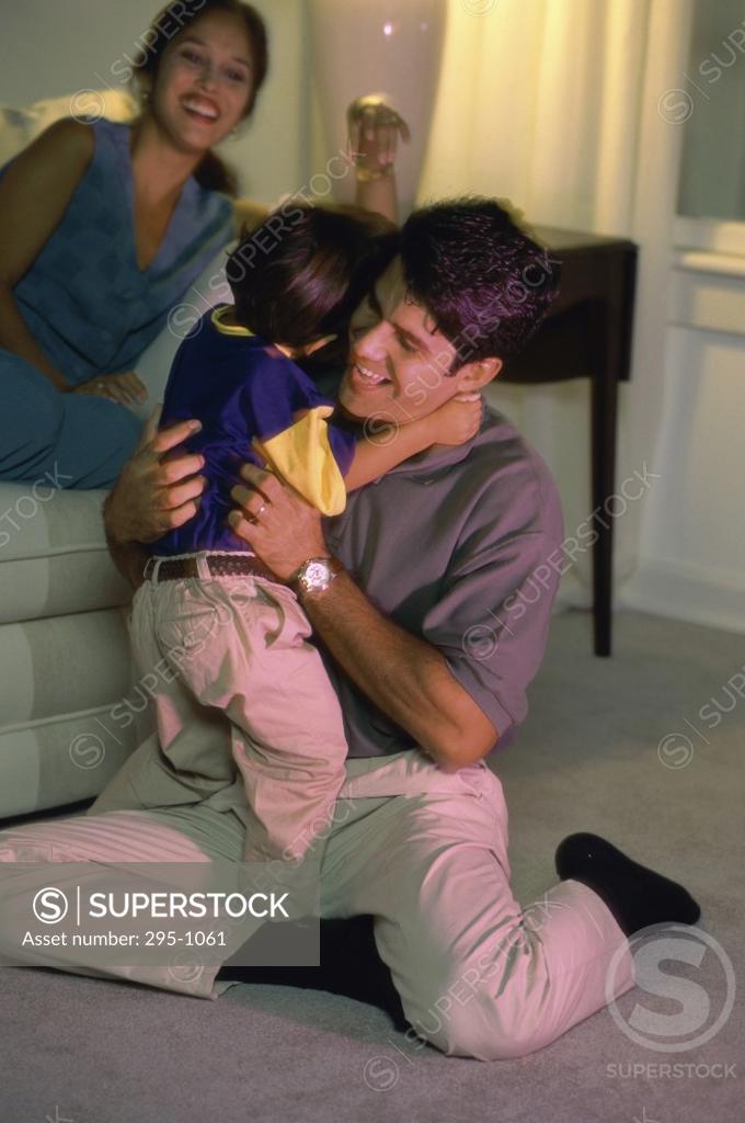 Stock Photo: 295-1061 Mid adult man hugging his son and smiling