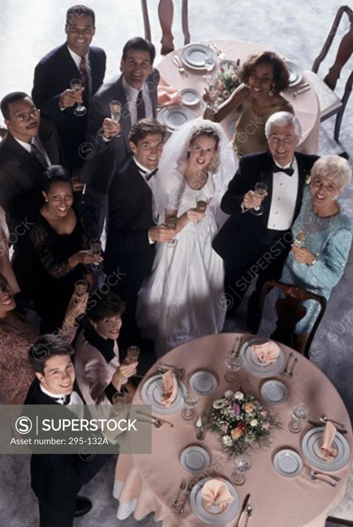 Stock Photo: 295-132A Portrait of a newlywed couple standing with their parents and wedding guests holding champagne flutes