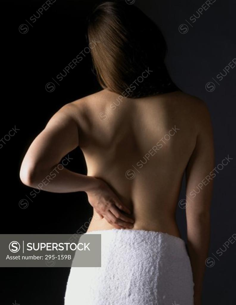 Stock Photo: 295-159B Rear view of a young woman suffering from a backache