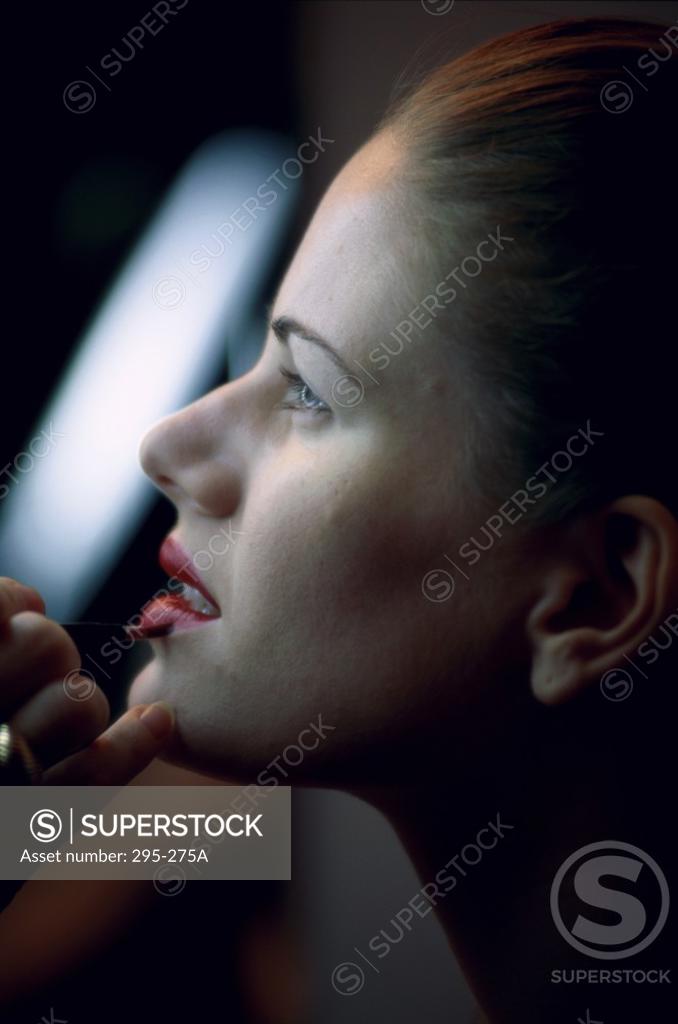 Stock Photo: 295-275A Make-up artist applying lipstick to a young woman