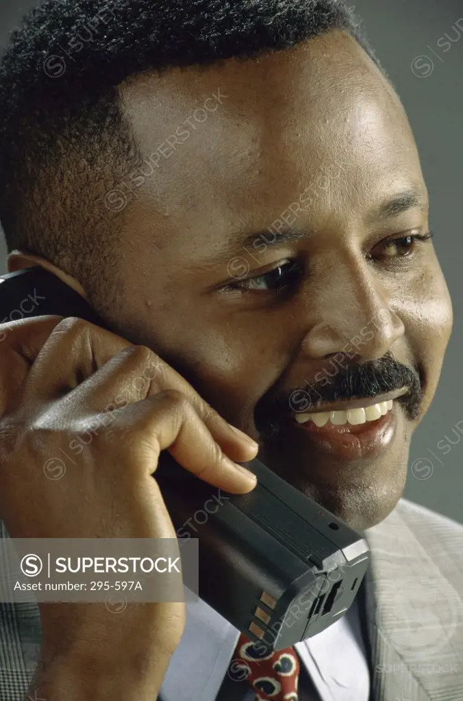 Close-up of a businessman talking on a cordless phone and smiling