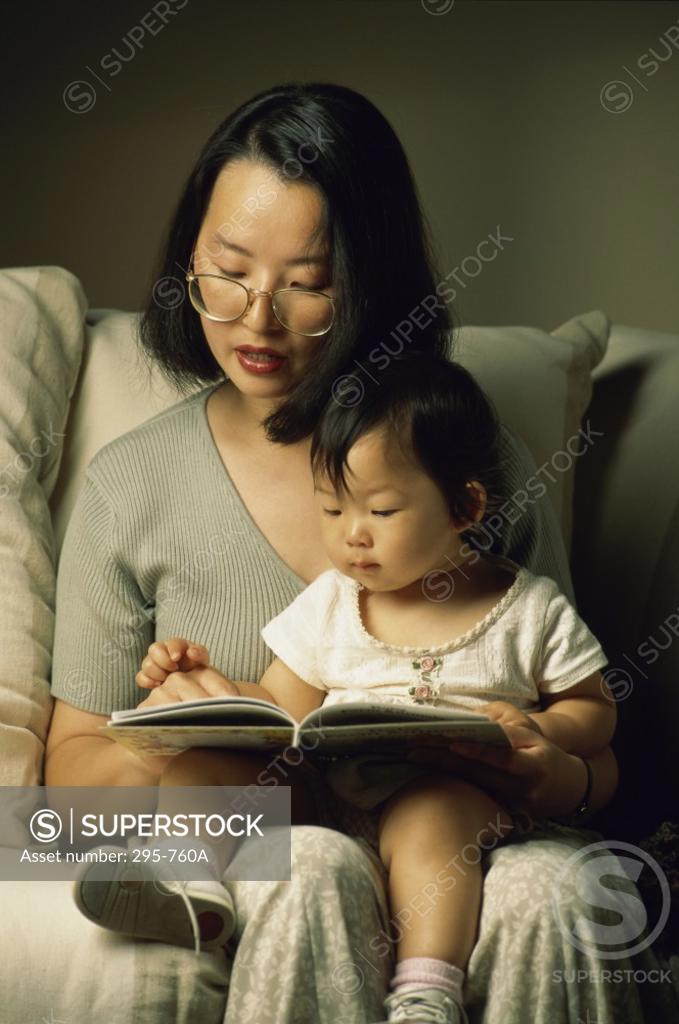 Stock Photo: 295-760A Young woman reading a book to her daughter