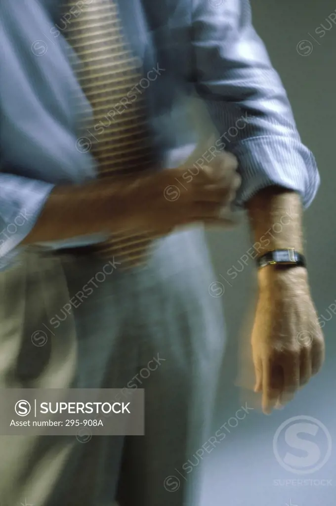 Mid section view of a businessman rolling up his sleeves