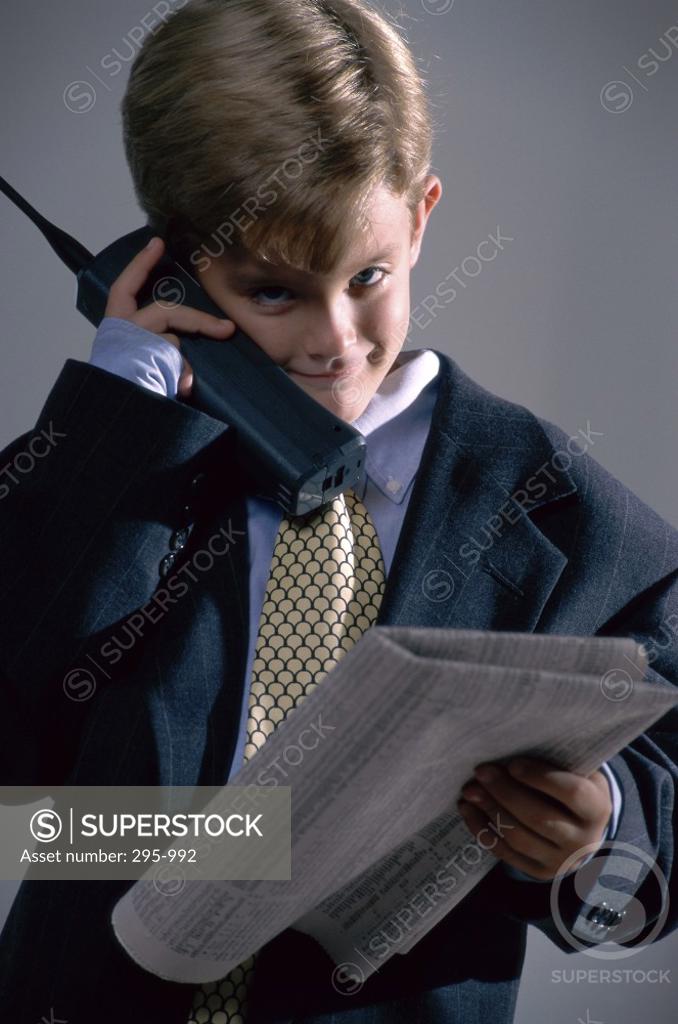 Stock Photo: 295-992 Boy dressed as a businessman using a cordless phone