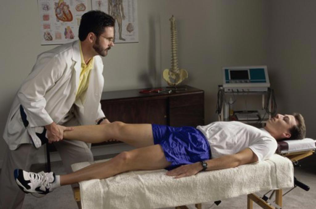 Male chiropractor examining a patient in a doctor's office