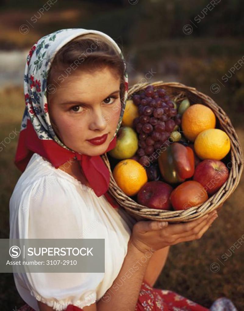 Stock Photo: 3107-2910 Portrait of a young woman holding a basket of fruit