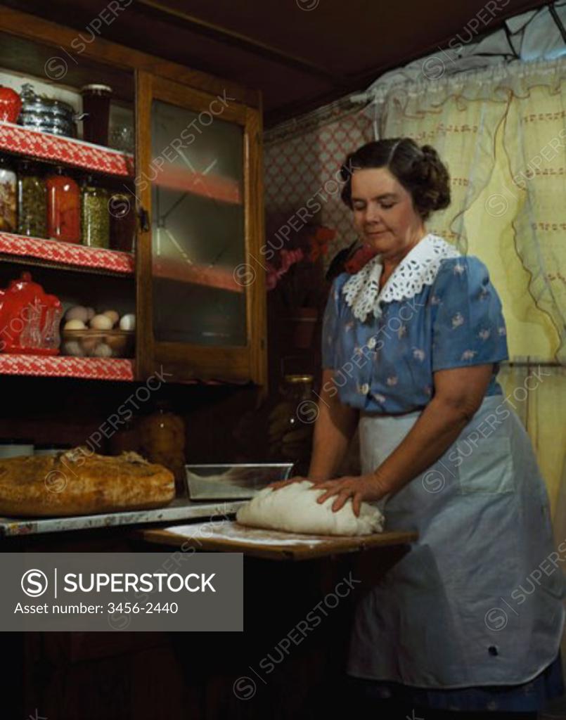 Stock Photo: 3456-2440 Mature woman kneading dough in a domestic kitchen