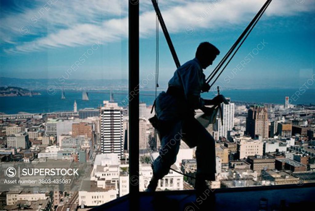 Stock Photo: 3803-435087 Silhouette of a window washer at the top of Mark Hopkins Hotel, San Francisco, California, USA