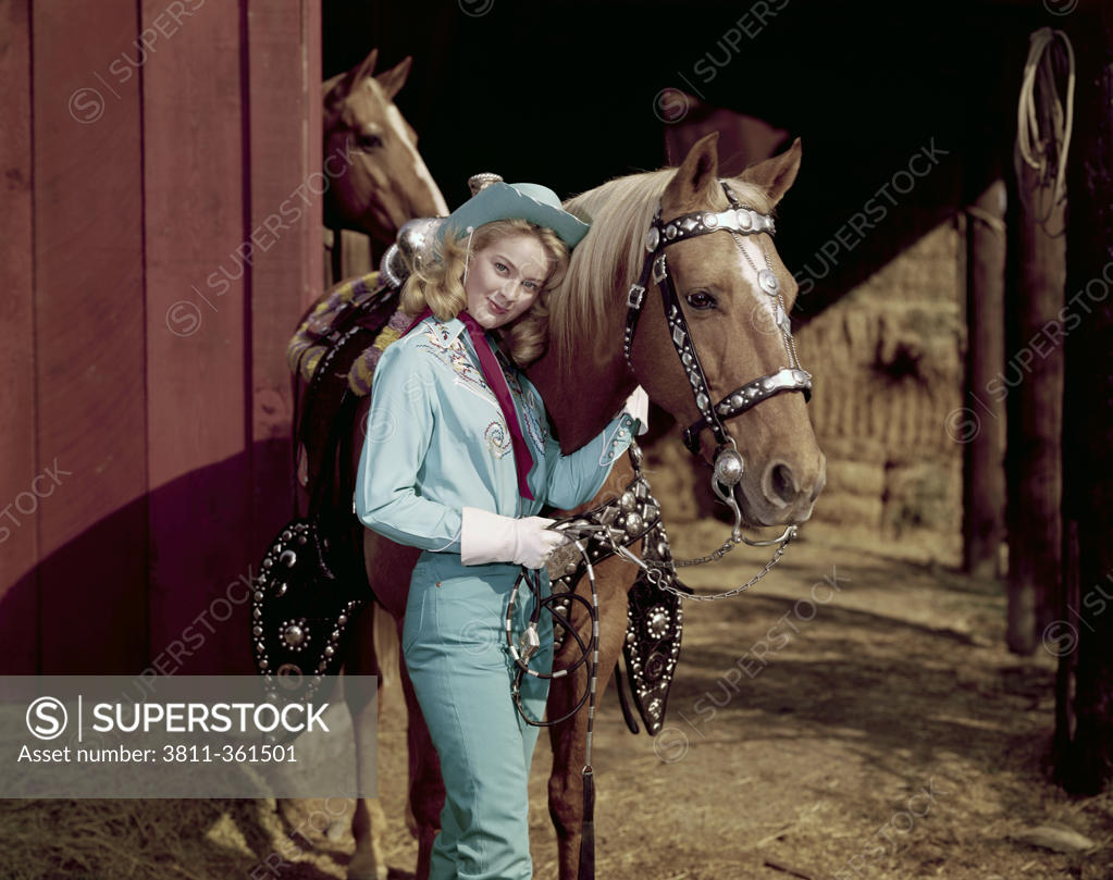 Stock Photo: 3811-361501 Portrait of a young woman standing near a horse