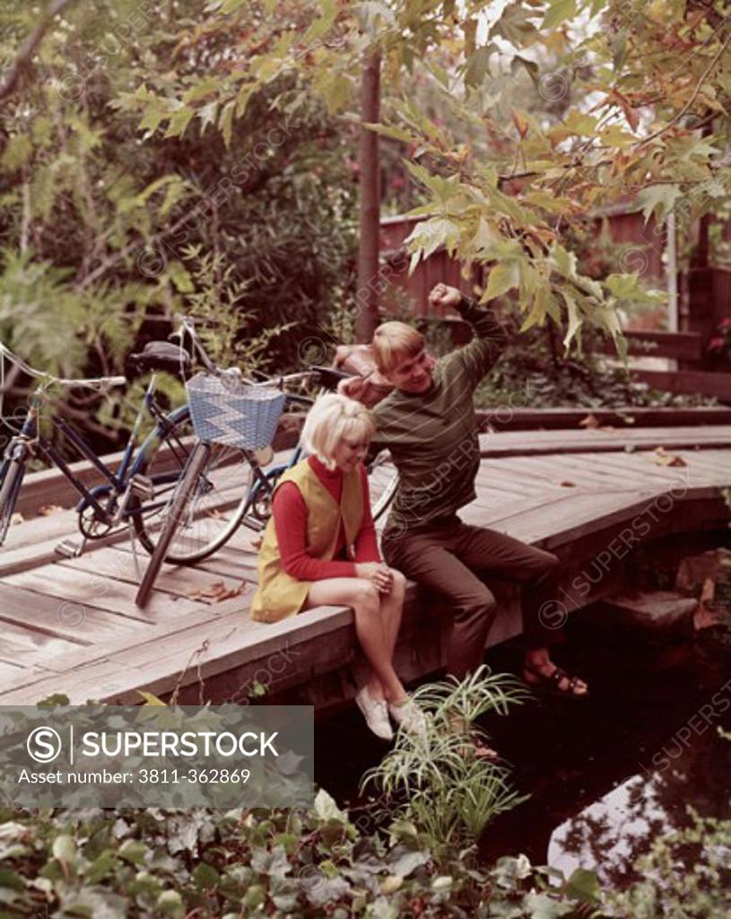 Stock Photo: 3811-362869 High angle view of a teenage couple sitting on a wooden bridge