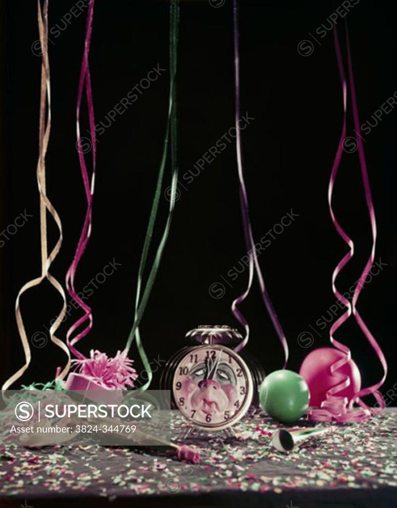Stock Photo: 3824-344769 Studio shot of alarm clock with party horn blowers and confetti