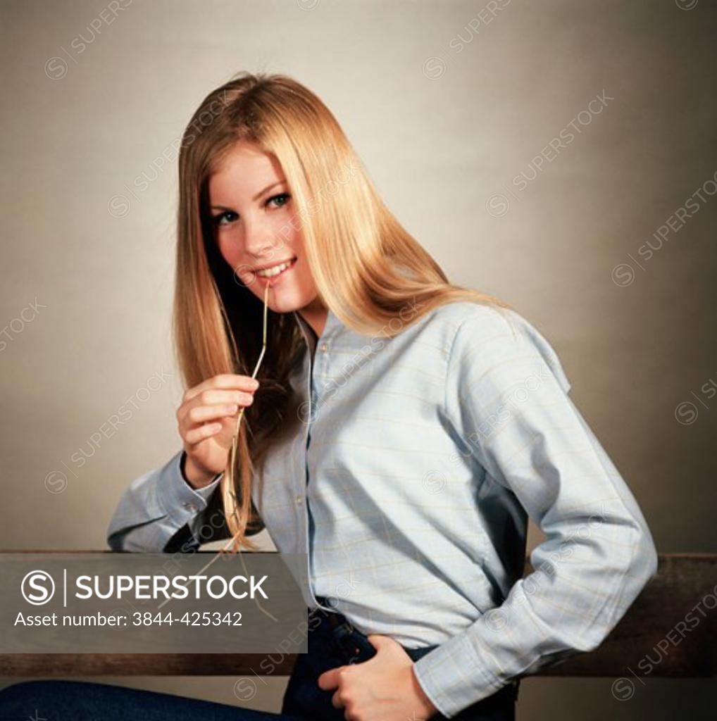 Stock Photo: 3844-425342 Portrait of a teenage girl chewing a piece of straw