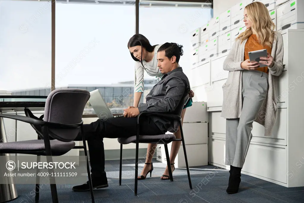 Three co-workers gather around a conference table.