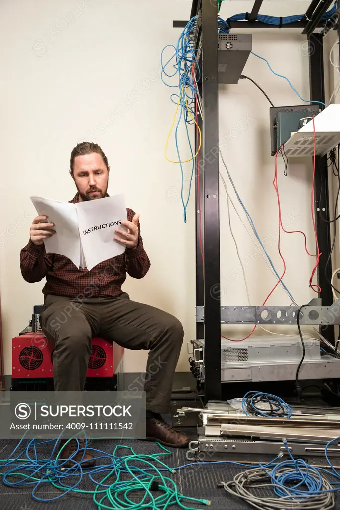 An IT employee looks confused while putting together a server.